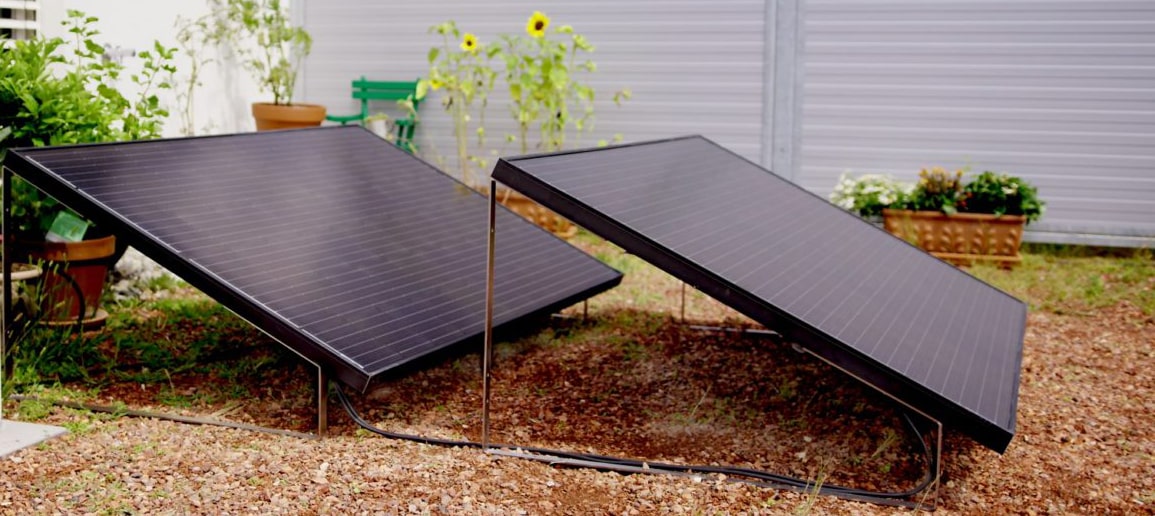 Zwei Lightmate G Solarmodule hintereinander im Garten aufgestellt.